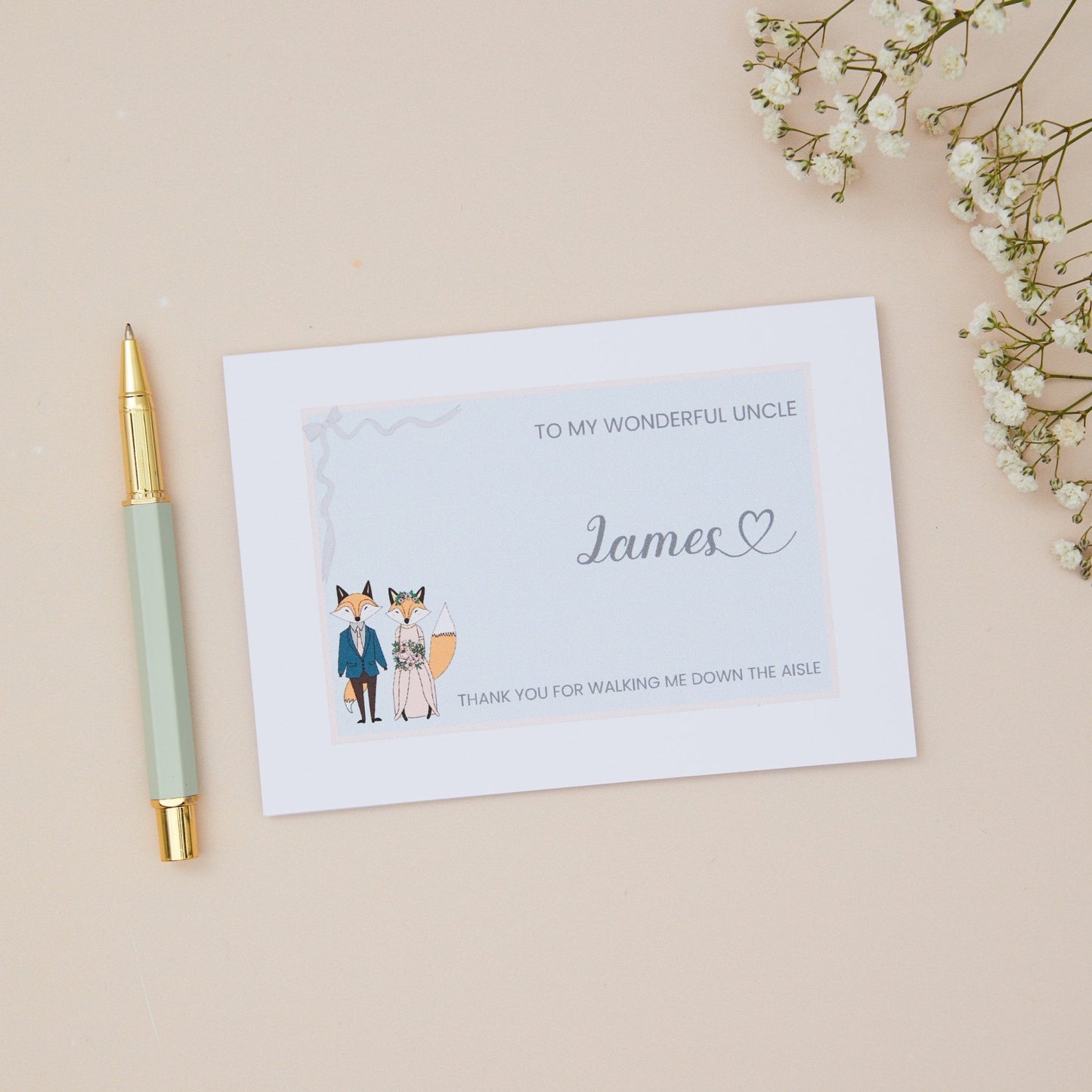 Uncle Thanks for walking me down the Aisle Card. A Fox Couple in their bridal attire with the label 'To my wonderful uncle thank you for walking me down the aisle. The Card is set against a pale beige background with stationery items.
