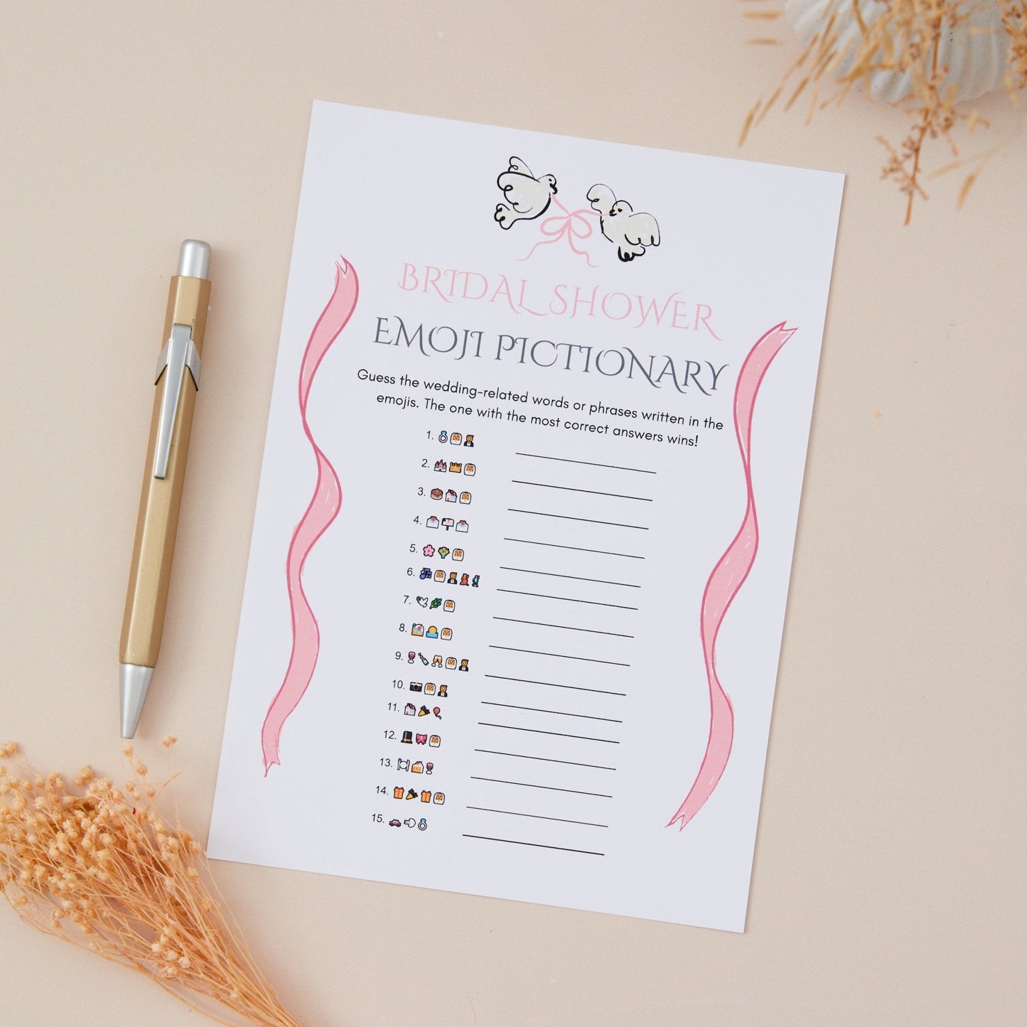 A Bridal Shower hen do Emoji Pictionary game card displayed on a table with a pen and decorative items in the background.