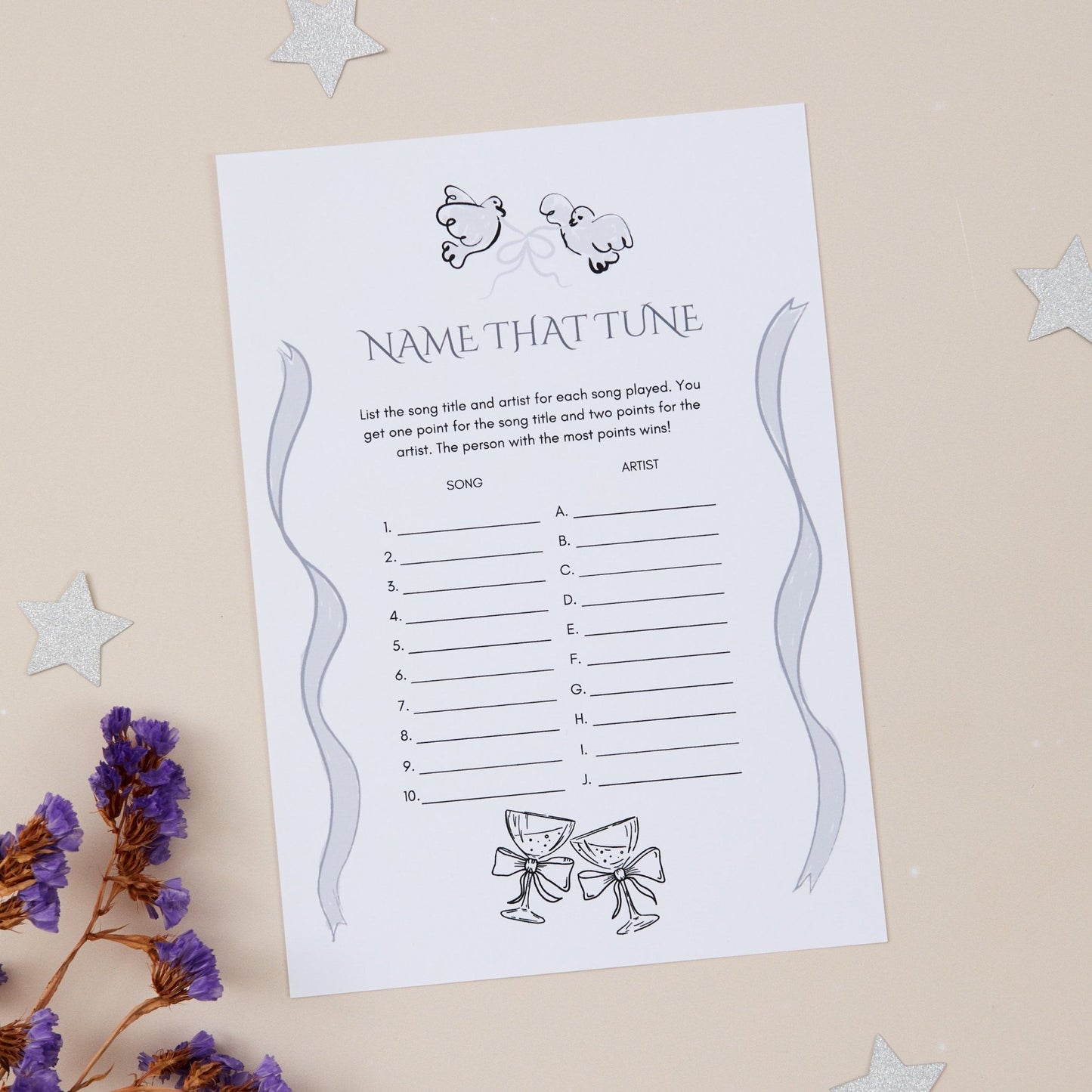 A5 size 'Name that Tune' wedding reception game card with a list of songs to guess the title and artist, placed on a table with decorative stars around it.