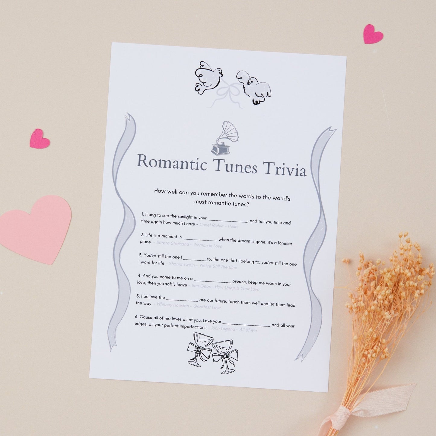A5-sized card with 'Romantic Tunes Trivia' game text, illustrations of a gramophone and celebratory champagne glasses with bows. There is a list of questions and spaces for answers.