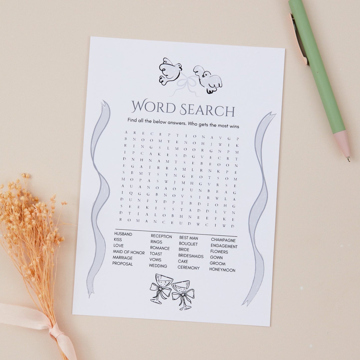 A5-sized 'Word Search' wedding game card with a list of hidden words to be found by guests, placed on a table with a pencil and decorative flowers beside it.