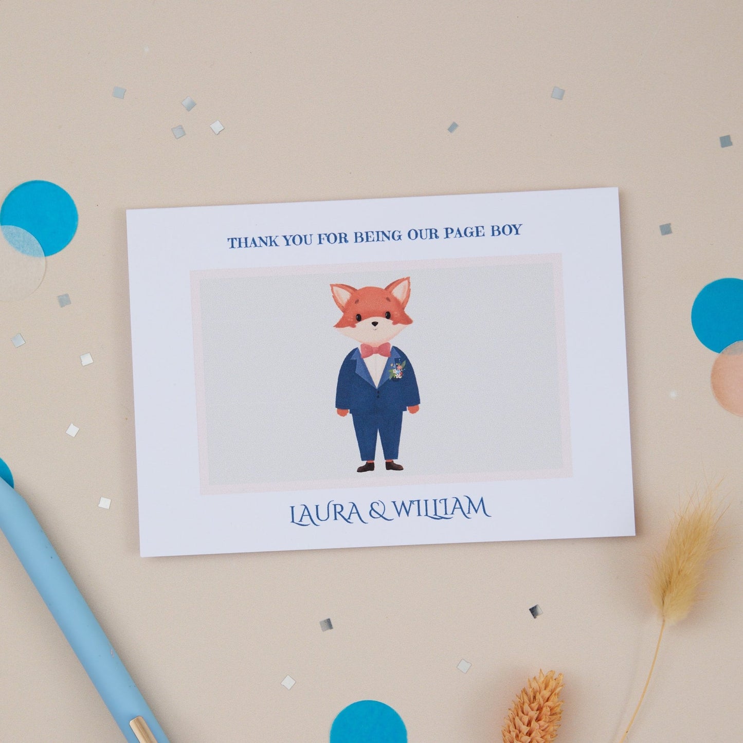 A 'Thanks For Being Our Page Boy' A6 sized greeting card with an illustration of a fox in a page boy outfit. The card is set against a neutral background with some decorative elements like blue confetti and a blue pen.