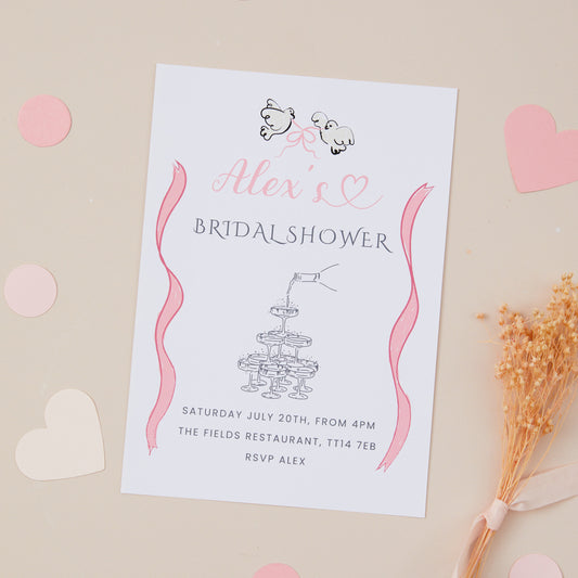 A bridal shower hen do invitation with pink accents and decorative elements, including a champagne glasses tower with champagne being poor from the top of the tower. There are hearts, displayed on a beige background with confetti and a dried flower.